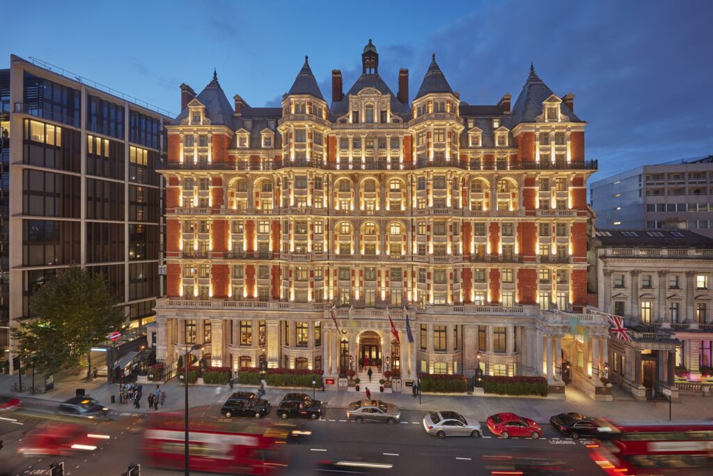 The exterior of the Mandarin Oriental Hyde Park in London illuminated at night, showcasing its grandeur.