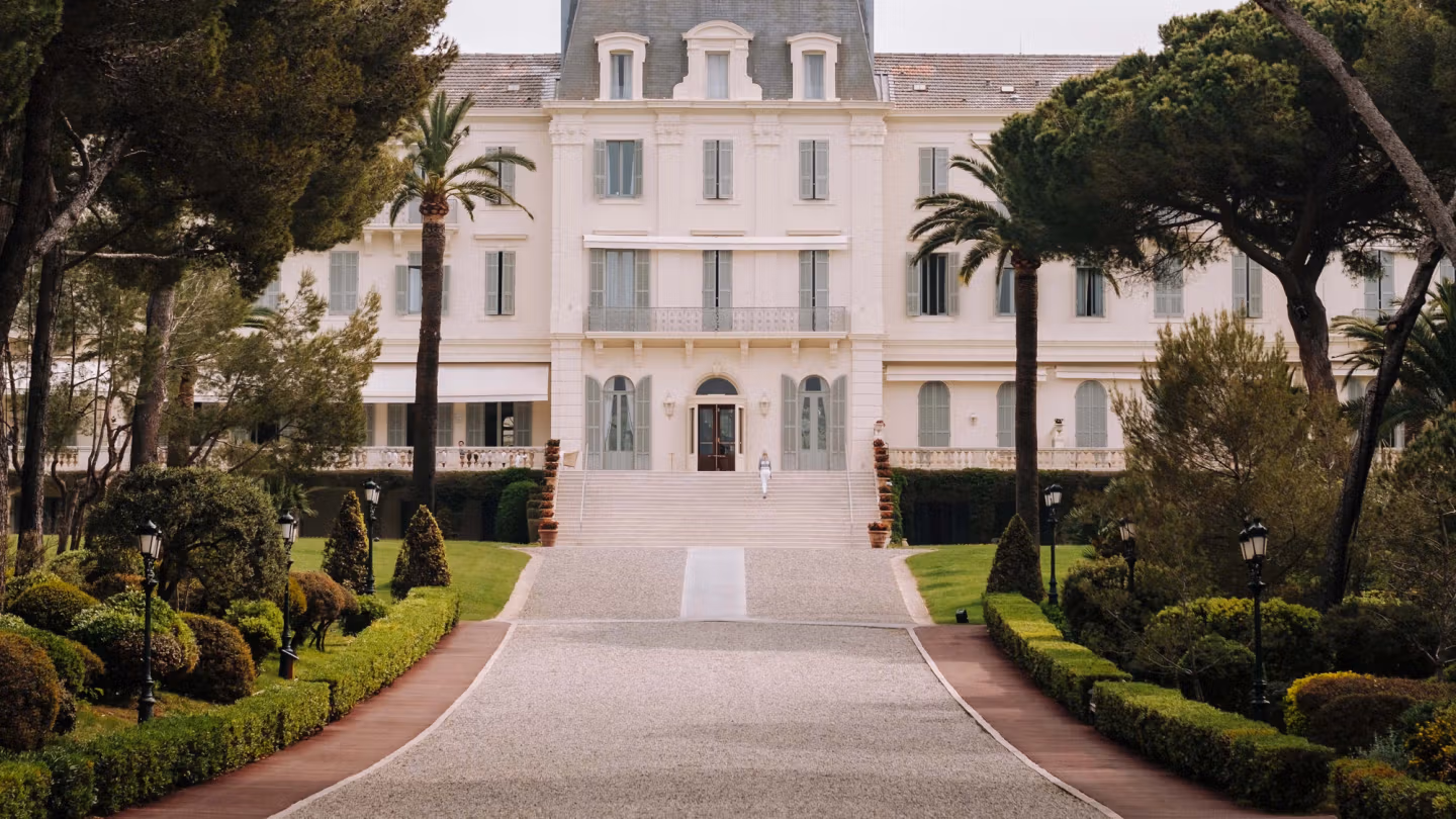of Hotel du Cap-Eden-Roc, a historic luxury wedding venue on the French Riviera, featuring a grand white façade and manicured gardens.