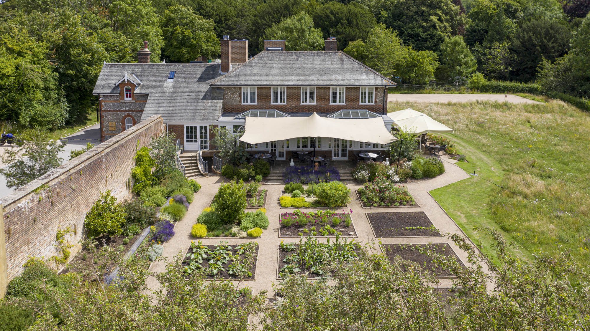 A picturesque countryside venue with a walled garden and charming brick house, ideal for an eco-luxury wedding curated by a wedding organiser in London.